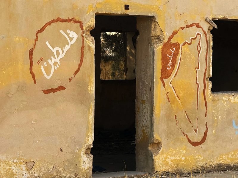 A weathered doorway in a graffiti-marked wall